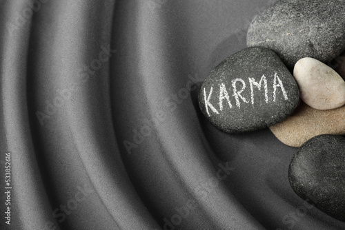 Tableau sur toile Stones with word Karma on grey fabric, above view. Space for text