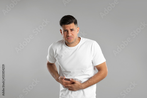 Man suffering from liver pain on grey background © New Africa