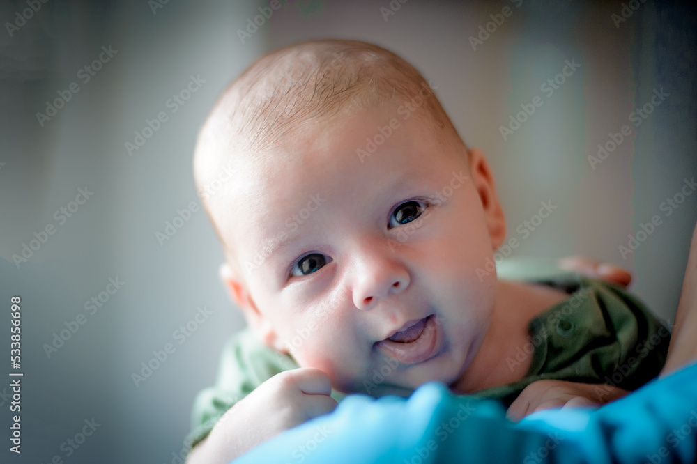 Close-up detail portrait of cute little peaceful newborn baby boy child face with beautiful open eyes. Love and family emotion