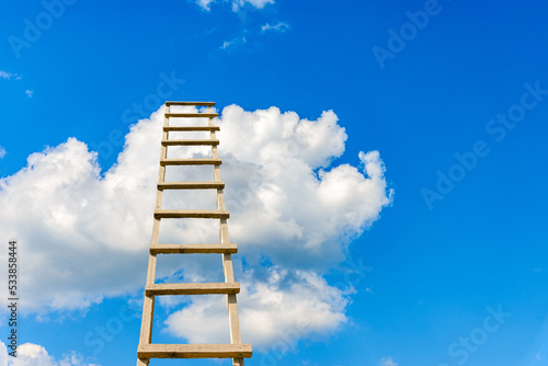 The way to success concept.Wooden ladder leading high up to the heaven.Blue sky and white clouds  success concept.Copy space.