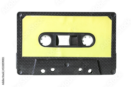 An old vintage cassette tape from the 1980s (obsolete music technology). Black hexagon grid plastic body, pale yellow empty label, isolated.
