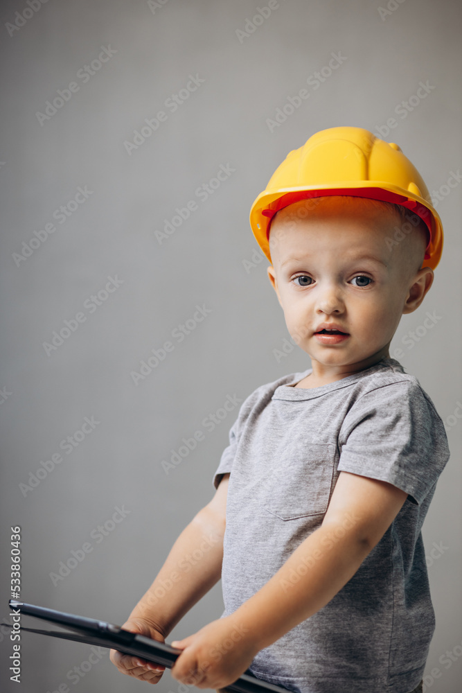 Cute little boy builder wearing helmet with tablet Cute little boy builder wearing helmet with tablet