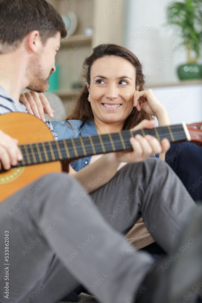 Fototapeta premium loving couple with guitar in the room at home