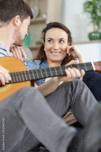 loving couple with guitar in the room at home