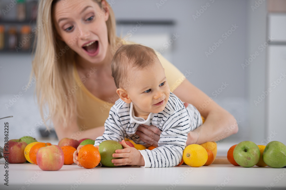 Fototapeta premium baby surrounded with fruits and vegetables