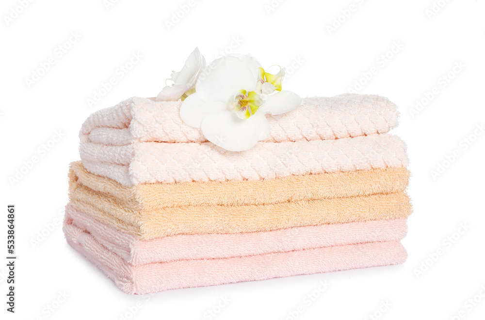 Stack of clean soft towels with orchids isolated on white Stack of clean soft towels with orchids isolated on white