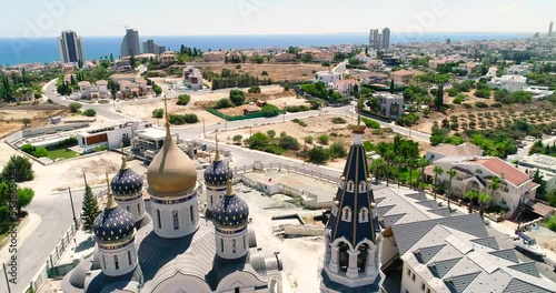 Aerial drone footage of the new Russian orthodox church Saint Nicholas in Limassol, Cyprus with sea view. Establish scene of golden dome, bell tower, cross of religious russian architecture from above photo