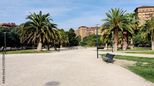 Tropical park with palm trees and cityscape in Zaragoza, slow motion view photo