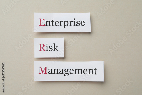 Cards with abbreviation ERM (Enterprise Risk Management) on beige background, flat lay