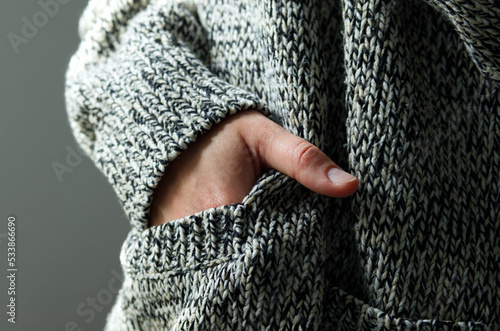 close-up of young woman in warm wool cardigan preparing for cold winter