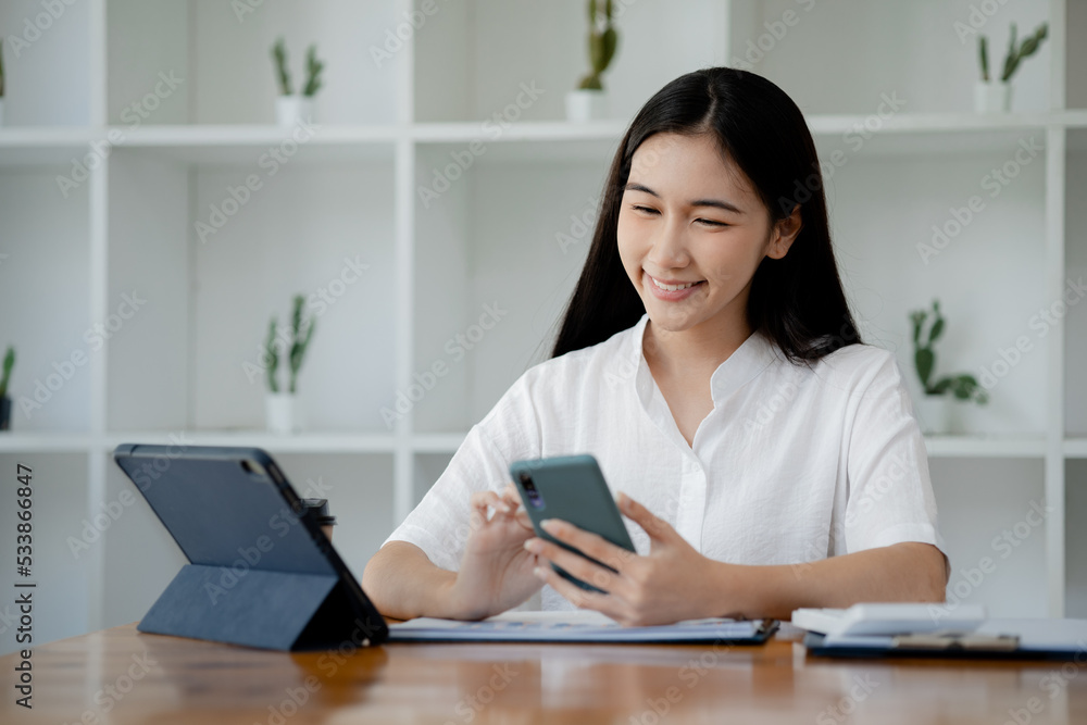 Woman gesturing and looking at the mobile phone, business woman checking company monthly sales and pretending to be happy as sales meet planned targets according to policy. Sales management concept. Woman gesturing and looking at the mobile phone, business woman checking company monthly sales and pretending to be happy as sales meet planned targets according to policy. Sales management concept.