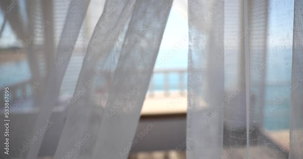 Awnings with fabric white curtains on seashore blow in wind Awnings with fabric white curtains on seashore blow in wind
