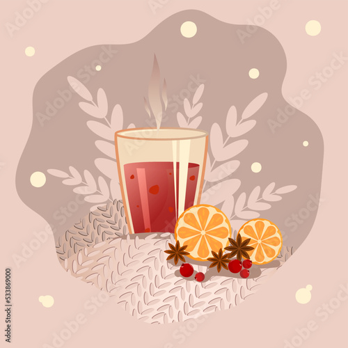 Mulled wine in a glass, standing on a plaid with a framed orange and leaves in the background