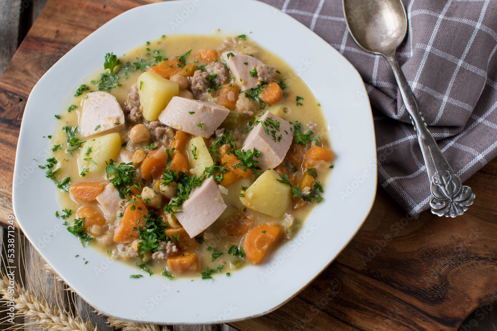 Savory stew with vegetables, potatoes, chickpeas, sausage and minced meat on a plate Savory stew with vegetables, potatoes, chickpeas, sausage and minced meat on a plate