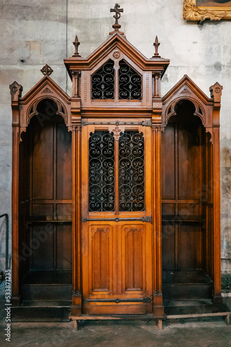 Antique wooden confessional box in dark wood in a church. Religious, Christian custom. making the confession