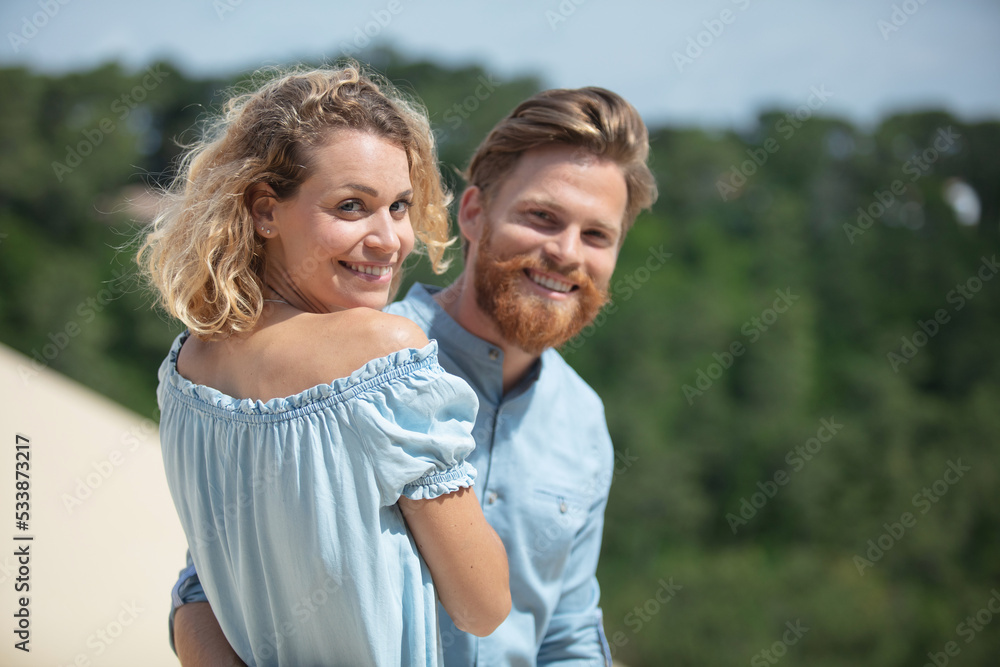 beautiful young couple relaxing together on sand dunes beach