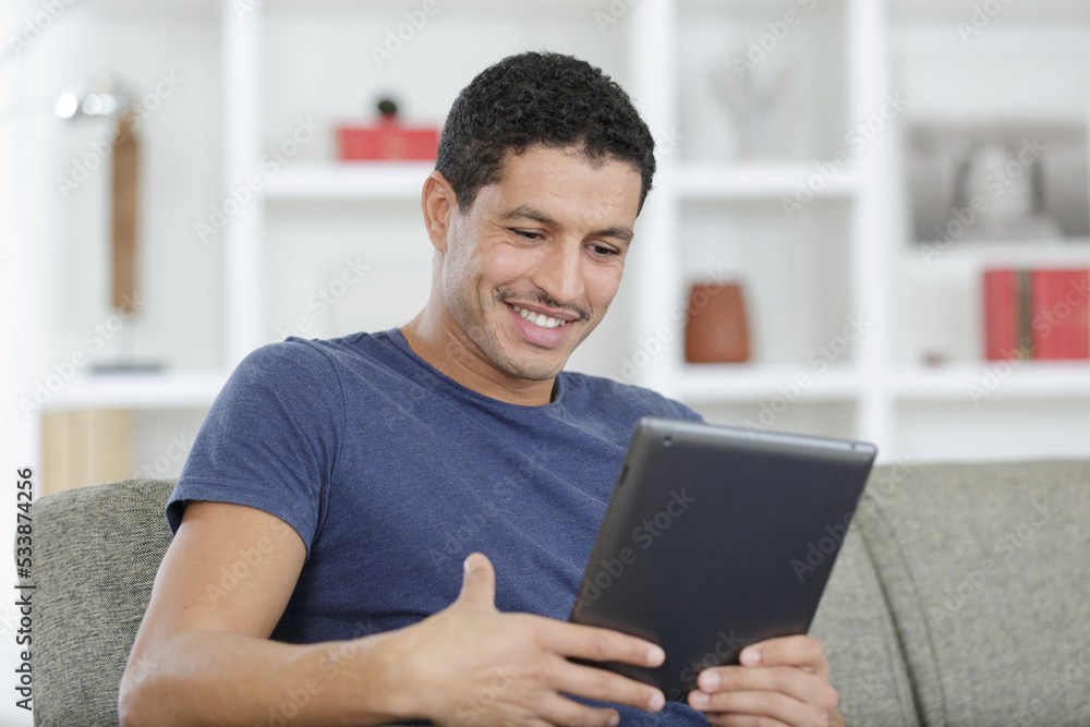 happy casual businees man is looking at the tablet happy casual businees man is looking at the tablet