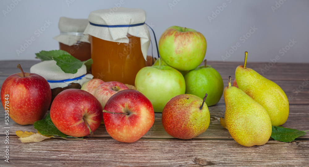 Ripe apples and pears and jars of apple jam on the table Ripe apples and pears and jars of apple jam on the table