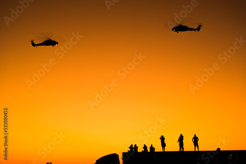 Silhouette of  Turkish gendarme helicopters on the sky with some photographers  on the liberty day of Izmir at Izmir Konak Turkey © ardasavasciogullari