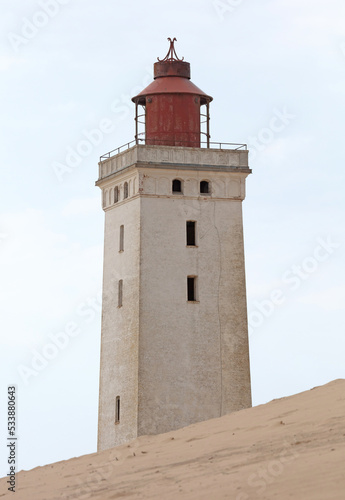 Lokken, Denmark - August 24, 2022: Rubjerg Knude Lighthouse, Denmark, that was put out of action because of the sandstorms, is now a big tourist attraction. Partial because of the huge sand dunes. © michaklootwijk