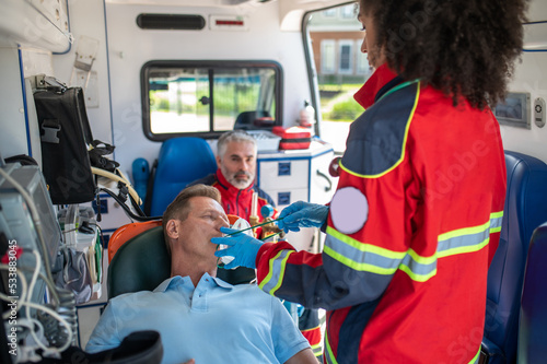 Ambulance personnel preparing a man for oxygen therapy