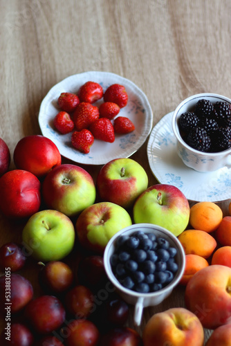 Various healthy seasonal food arranged on wooden background. Selective focus.