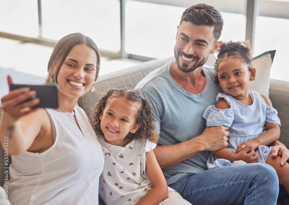 Family selfie, interracial smile and parents with phone for social media with children, happy on the sofa in house and relax with kids in home. Girl siblings taking photo with mother and father Family selfie, interracial smile and parents with phone for social media with children, happy on the sofa in house and relax with kids in home. Girl siblings taking photo with mother and father