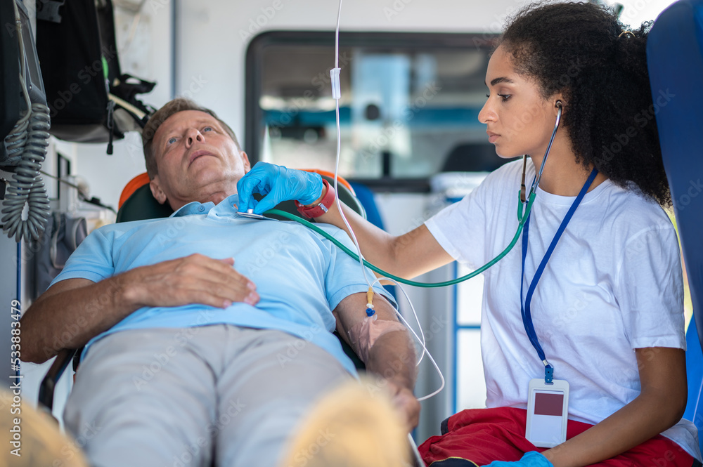 Obraz premium Focused female paramedic auscultating the ill person