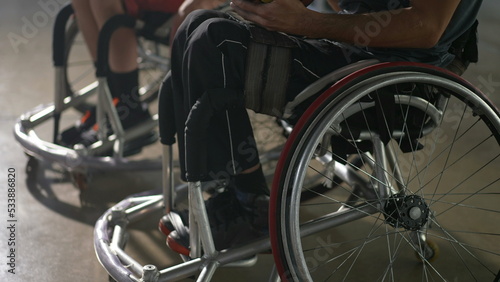 Two disabled handicapped basketball players in wheelchairs holding ball in hands