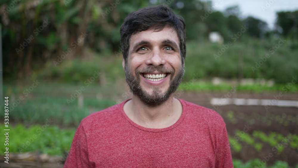 Portrait of a young man walking forward toward camera. Person walks in green agriculture farmland smiling Portrait of a young man walking forward toward camera. Person walks in green agriculture farmland smiling