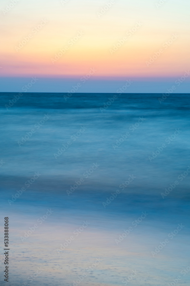 Naklejka premium Long exposure by the sea. Waves break against stones. Sunset at the beach. Long exposure at night by the sea. Patara Beach Antalya Turkey