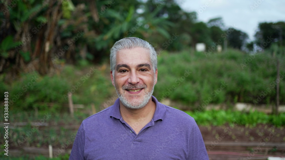 Happy older man walking forward in farm. Senior person portrait face at farmland Happy older man walking forward in farm. Senior person portrait face at farmland
