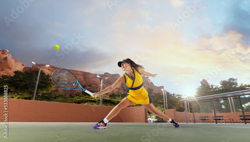 Woman playing tennis in professonal tennis court photo