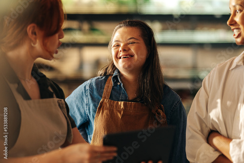 Retail worker with Down syndrome smiling during a staff meeting photo