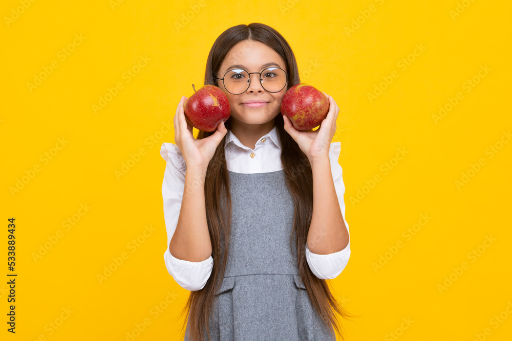 Teenager child with apple on yellow isolated background. apples are good for children. Happy girl face, positive and smiling emotions.