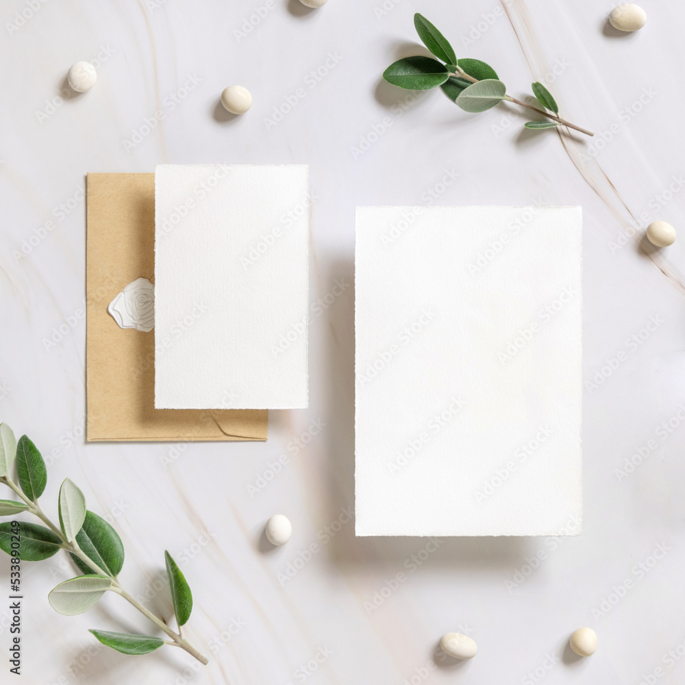 Cards and envelope on a marble table near eucalyptus branches and pebbles top view, Wedding mockup Cards and envelope on a marble table near eucalyptus branches and pebbles top view, Wedding mockup