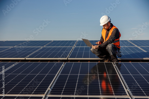 New technologies and solar panels. The supervisor is checking on solar panels on the rooftop. photo