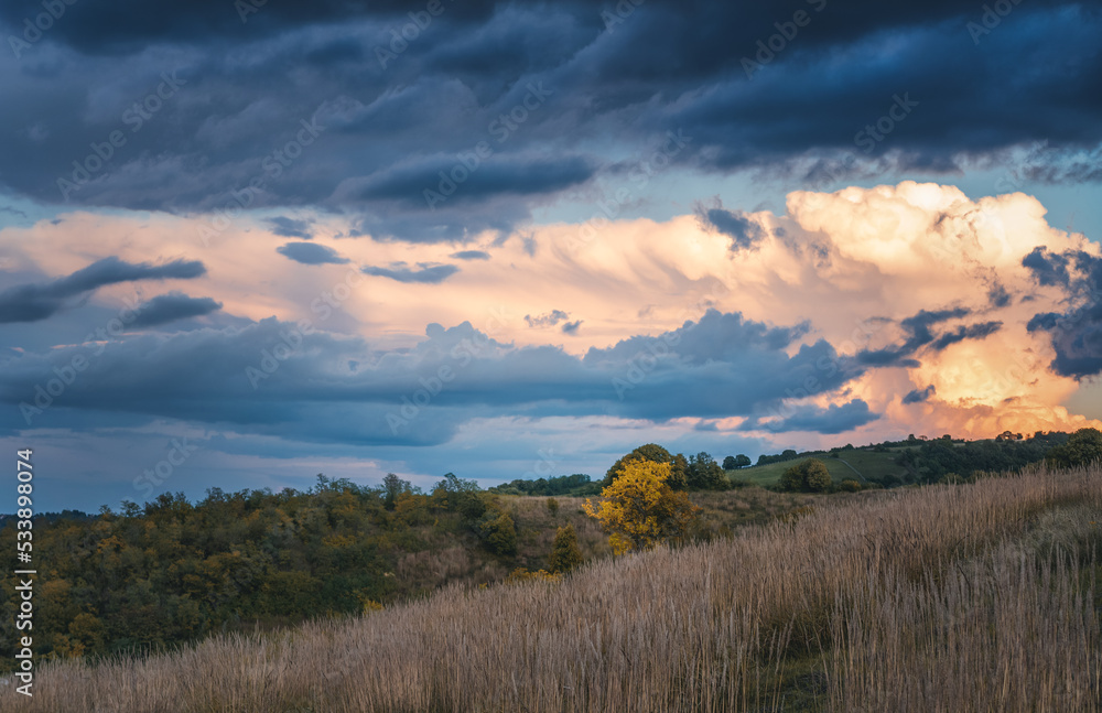 Beautiful autumn landscape, a field at sunset with a bright cloudy sky