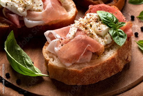 Obraz na plátně Deliziosi crostini conditi con prosciutto crudo, mozzarella e olio di oliva, cib
