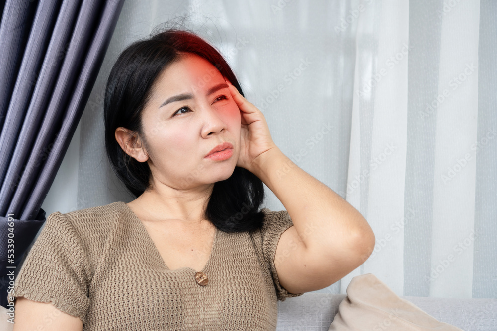 Asian woman having migraine headache feeling pain in one side of her head Asian woman having migraine headache feeling pain in one side of her head
