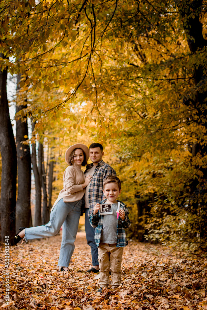Young family, husband, wife and young son holding a positive pregnancy test, waiting for replenishment in the family. Family autumn photo shoot Young family, husband, wife and young son holding a positive pregnancy test, waiting for replenishment in the family. Family autumn photo shoot