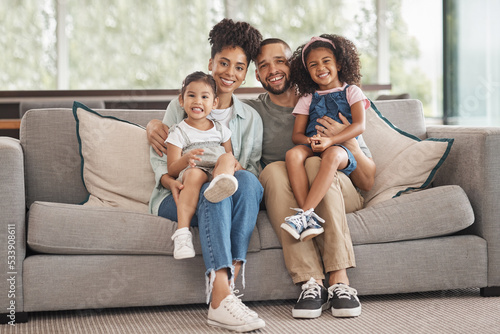 Happy interracial family on sofa portrait of children and parents or mother and father for love, care and support. An immigrant Mexico dad and mom with Asian and african kid together on lounge couch photo