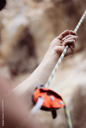 Billede på lærred Man's hands operating a rock climbing belaying device