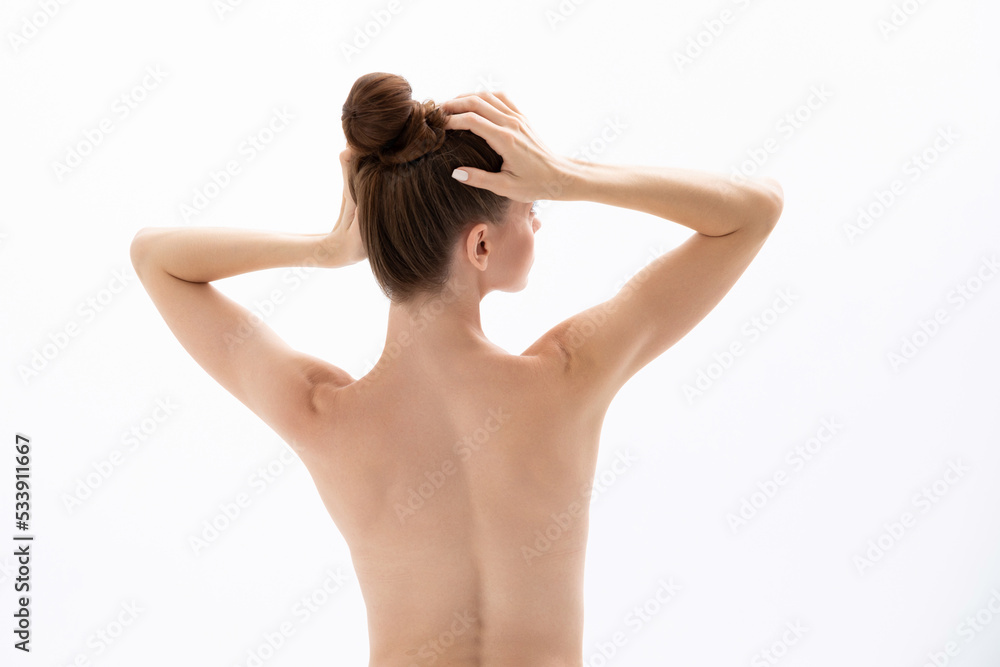 A young woman touches her head and demonstrates products for hair and skin. A young woman touches her head and demonstrates products for hair and skin.