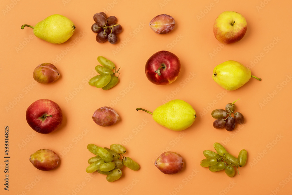 Composition of Fruits on a Orange Background Pattern Made From Fresh Fruits Top View Orange Background Collage of Plum Grapes Apples and Pears