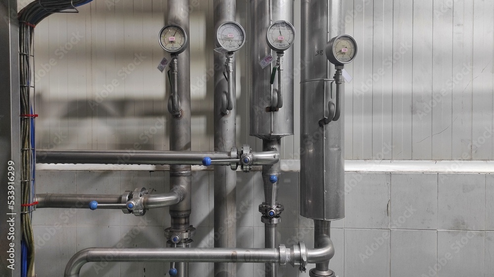 Industrial background of stainless steel pipes and gauges in production room of factory Industrial background of stainless steel pipes and gauges in production room of factory