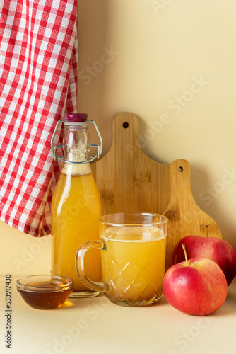 Cup and Bottle with Apple Cider with Cinnamon and Honey Yellow Background Seasonal Apple Mulled Wine Vertical