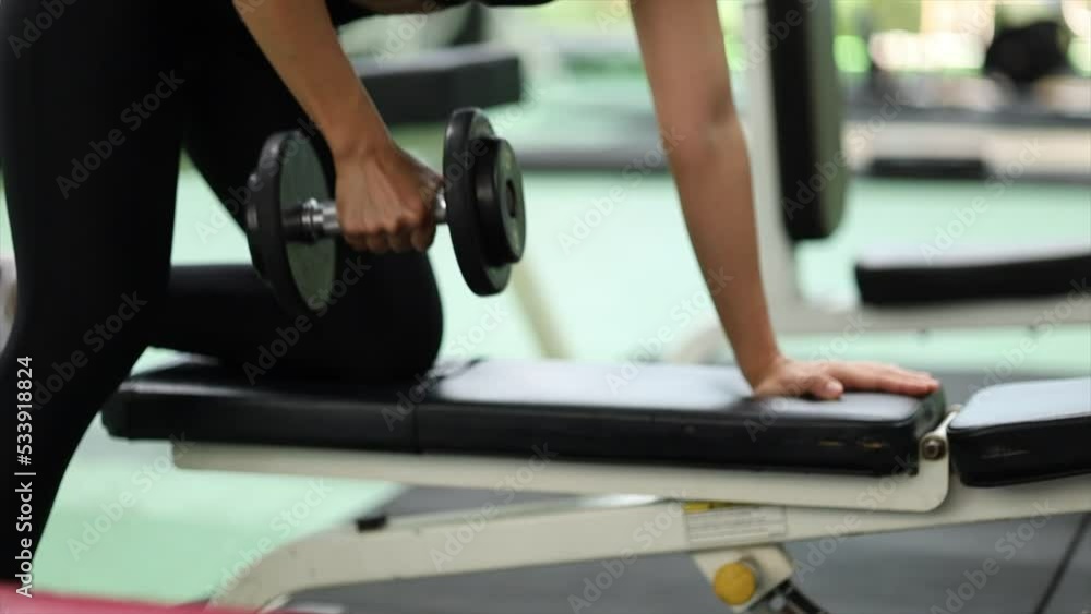 Asian women doing dumbbell exercises in fitness, exercise to strengthen muscles and strength, lose body fat, warm up before exercise, exercise in Fitness. Concept of health care women. Asian women doing dumbbell exercises in fitness, exercise to strengthen muscles and strength, lose body fat, warm up before exercise, exercise in Fitness. Concept of health care women.