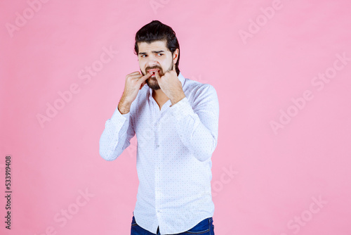 Photos Man in a white shirt whisting with fingers