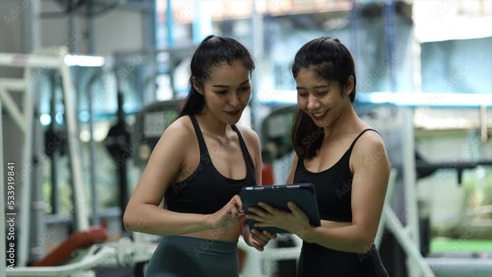 Two women training in a fitness center, a female trainer and a client chatting in the gym to explain the training program details, how to get fit and lose weight. Fitness training concept. Two women training in a fitness center, a female trainer and a client chatting in the gym to explain the training program details, how to get fit and lose weight. Fitness training concept.